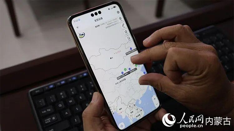 魏军手机屏幕展示佩戴GPS跟踪器的遗鸥实时轨迹，经纬度、海拔、活动量数据清晰可见。人民网记者 孟佳澍摄