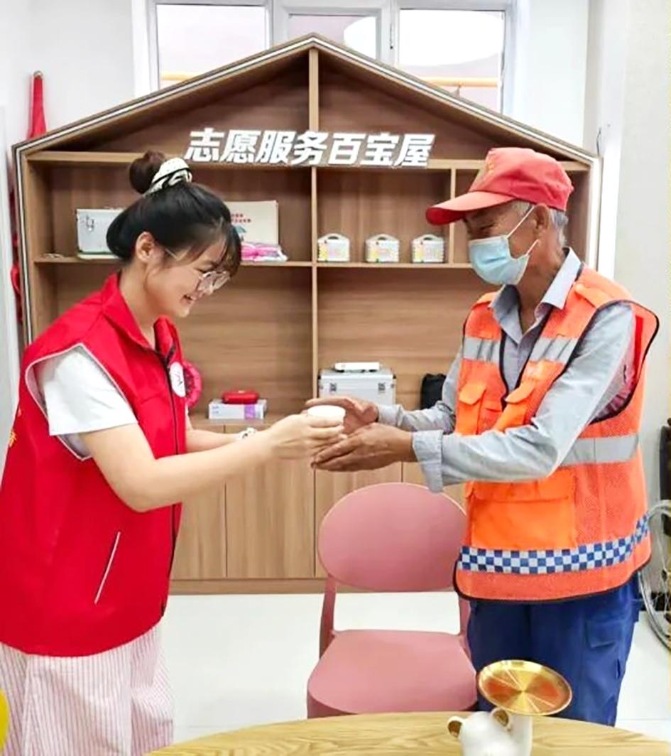 志愿者给环卫工人送上奶茶
